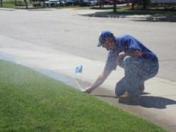 a Miami Gardens sprinkler repair professional is checking a sprinkler head